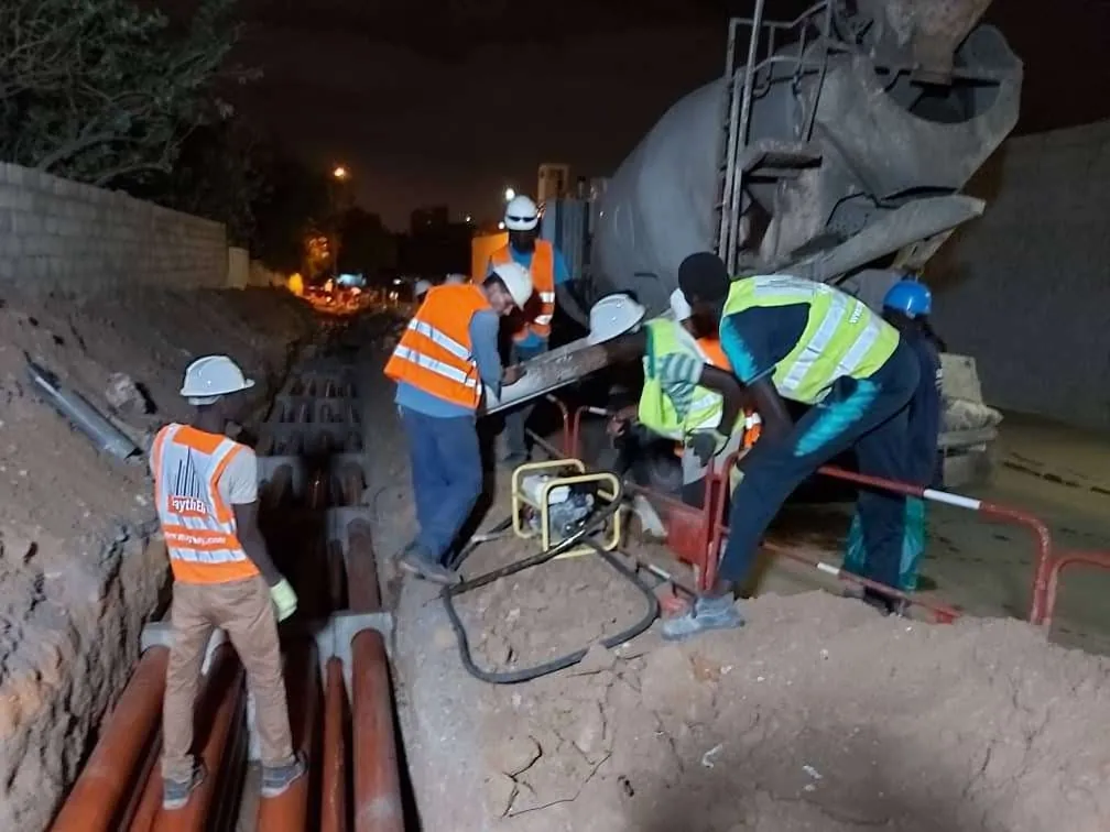 Bétonnage de nuit d'une tranchée de fourreaux, toupie et équipe en gilets orange