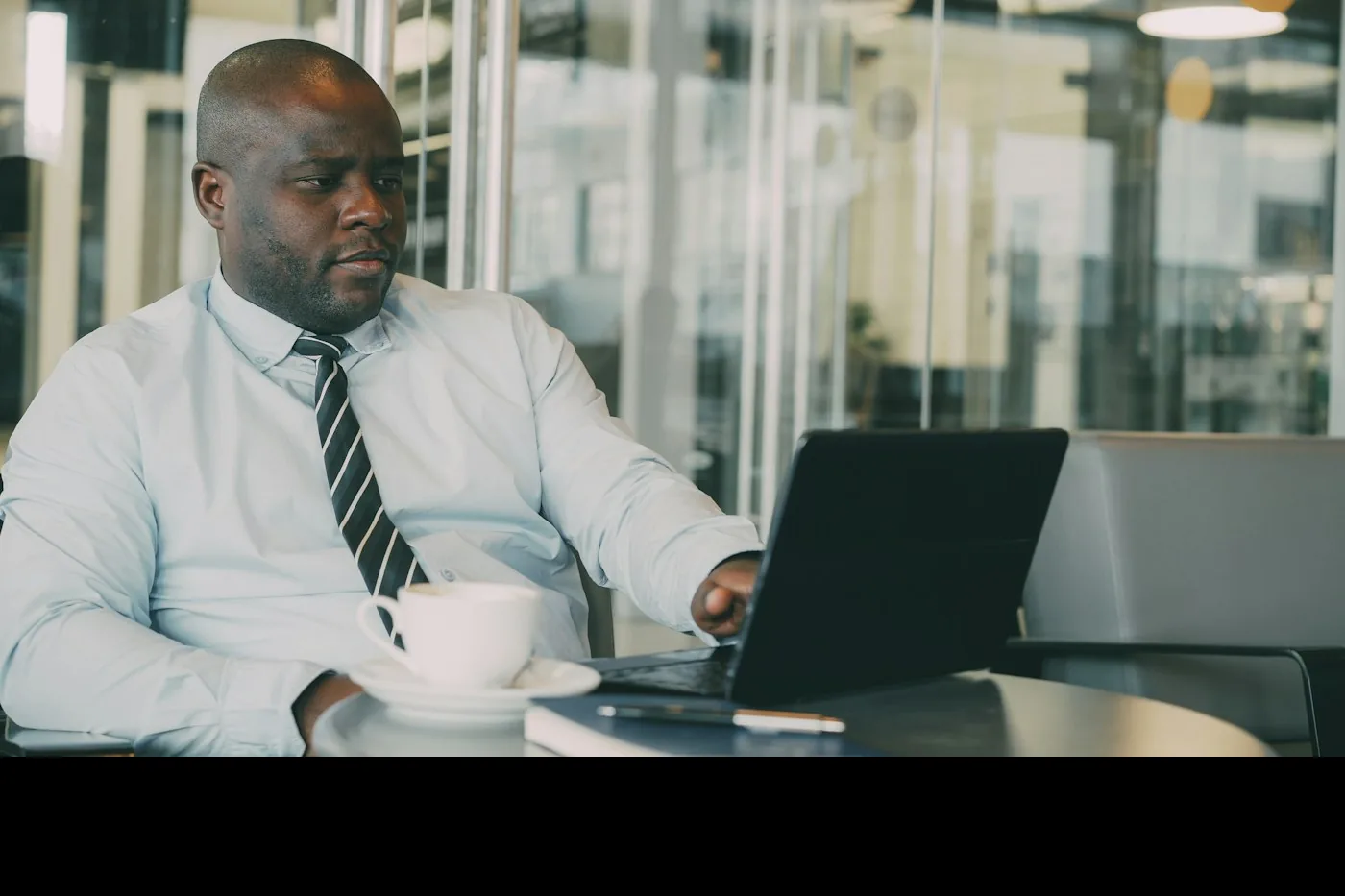 Responsable administratif et financier au travail sur un ordinateur portable, café à la main