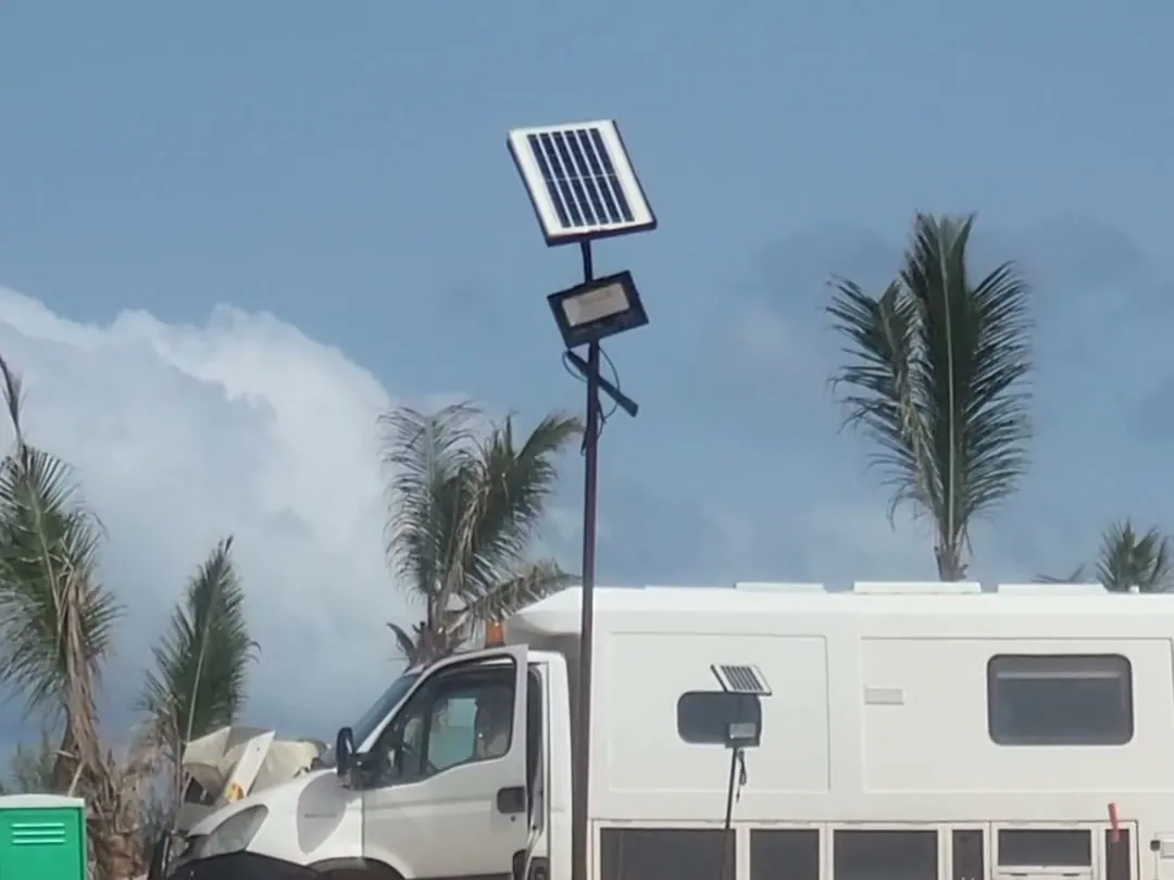 Solar-powered site lamp post: photovoltaic panel and floodlight